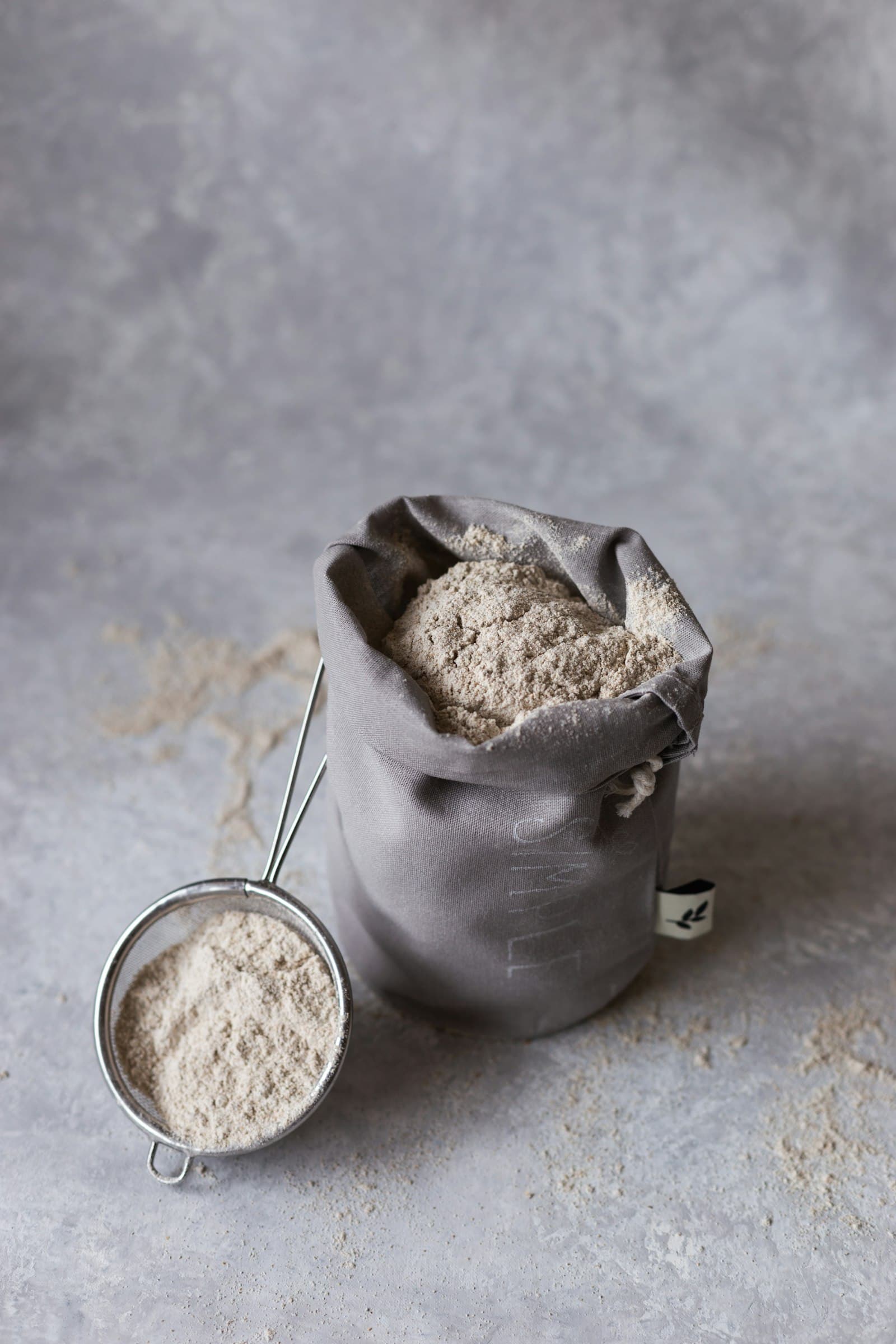Freshly milled millet flour in a sack and bowl