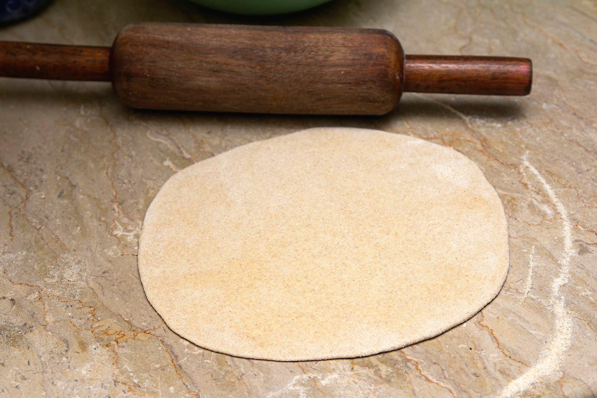 A roti rolled out with a wooden rolling pin